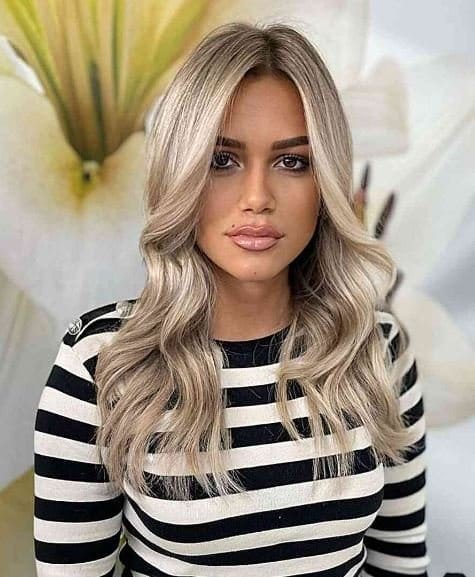 Dunkelwurzelig mit blonden, gekräuselten Enden